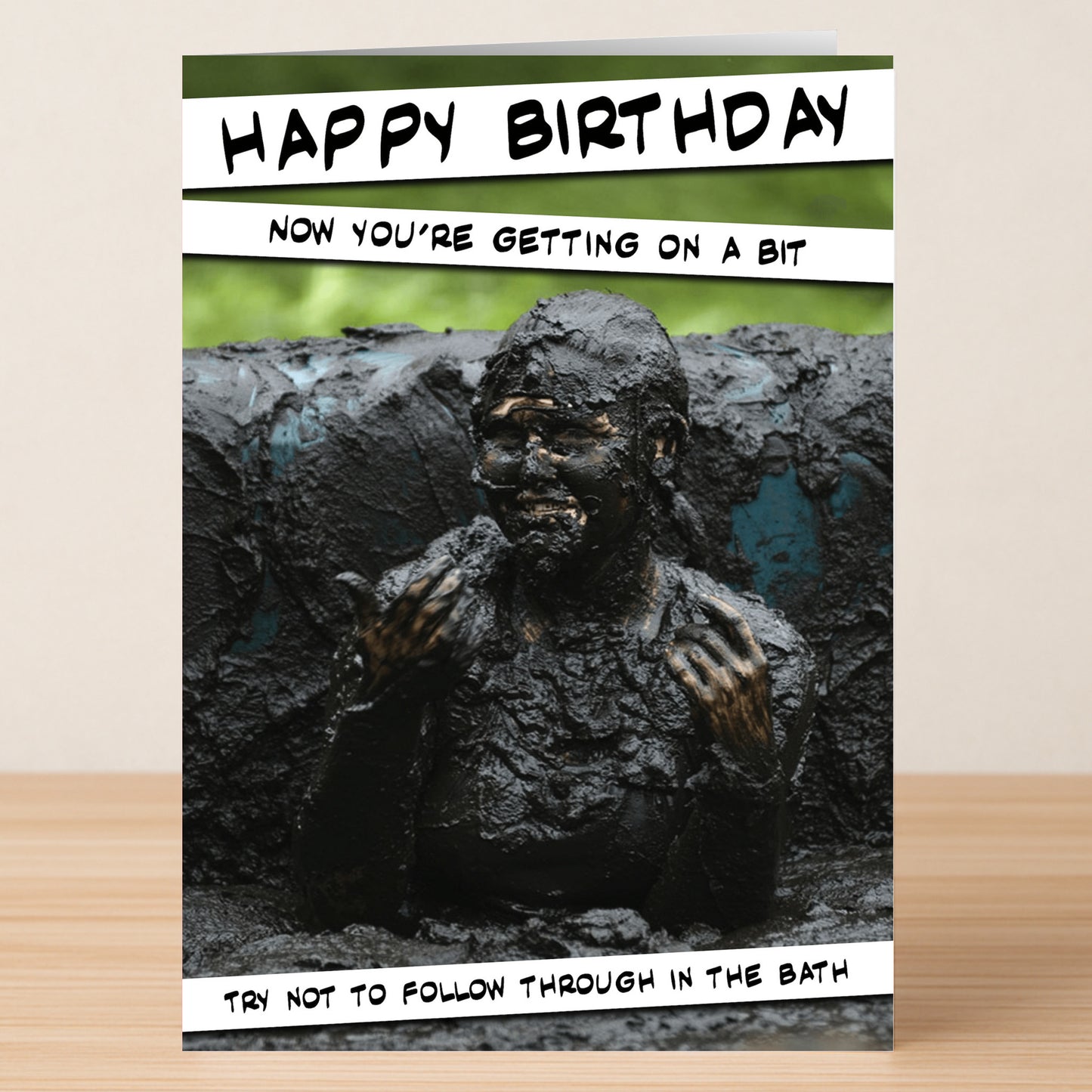 The Don’t Follow Through – Funny Birthday Card by Twisted Gifts shows a person covered in mud with the caption: "Happy Birthday. Now you're getting on a bit. Try not to follow through in the bath.
