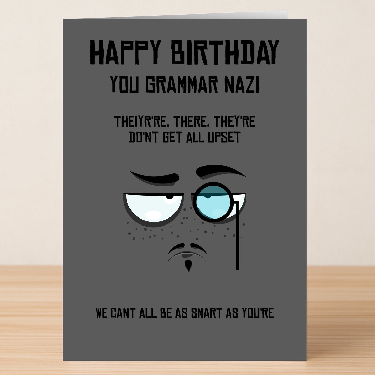 The Grammar Nazi – Funny Birthday Card by Twisted Gifts features a gray design with a cartoon monocle face and the text "Happy Birthday You Grammar Nazi," plus clever jokes about "their, there, they're." Ideal for language lovers.