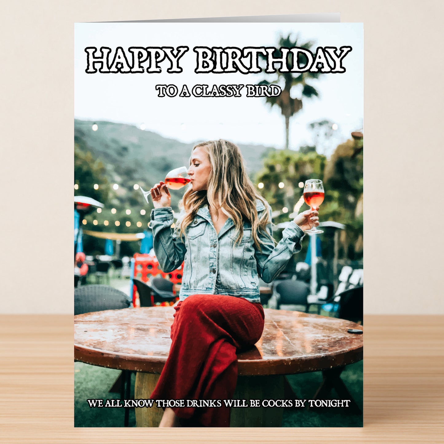 The Classy Bird – Rude Birthday Card by Twisted Gifts features a woman outside with two drinks and the cheeky message: "HAPPY BIRTHDAY TO A CLASSY BIRD. WE ALL KNOW THOSE DRINKS WILL BE COCKS BY TONIGHT.
