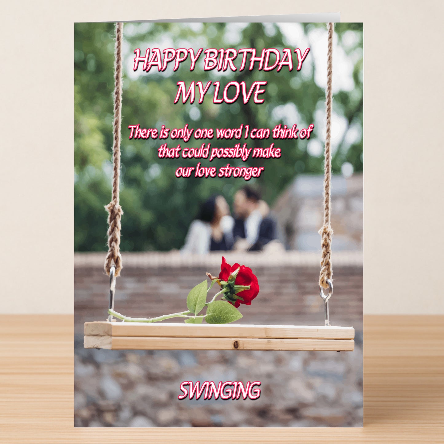 Swinging – Rude Birthday Card by Twisted Gifts: A humorous birthday card with a wooden swing holding two red roses, a blurred couple in the background, and playful text about love and swinging.