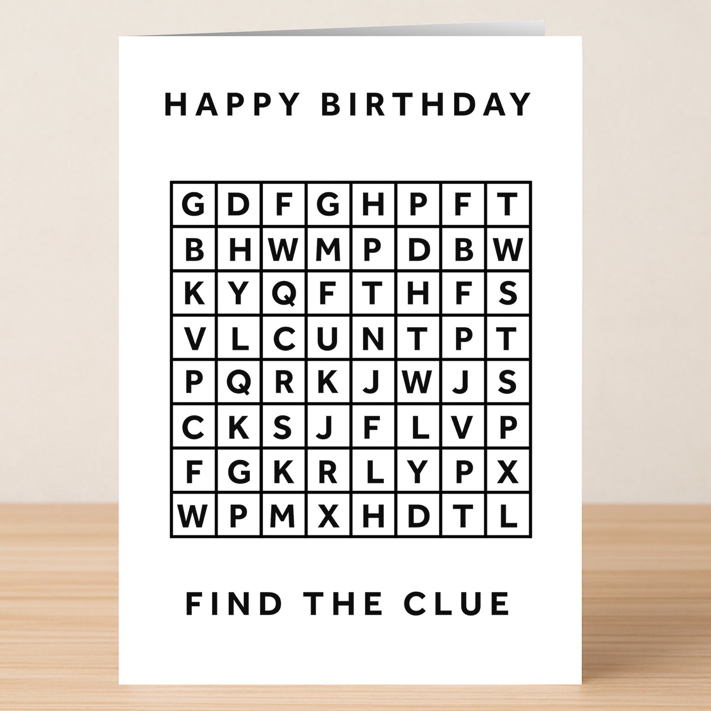 The "Word Search Cunt – Insulting Birthday Card" by Twisted Gifts features a black and white word search grid with "HAPPY BIRTHDAY" at the top and "FIND THE CLUE" at the bottom, shown on a wooden surface.