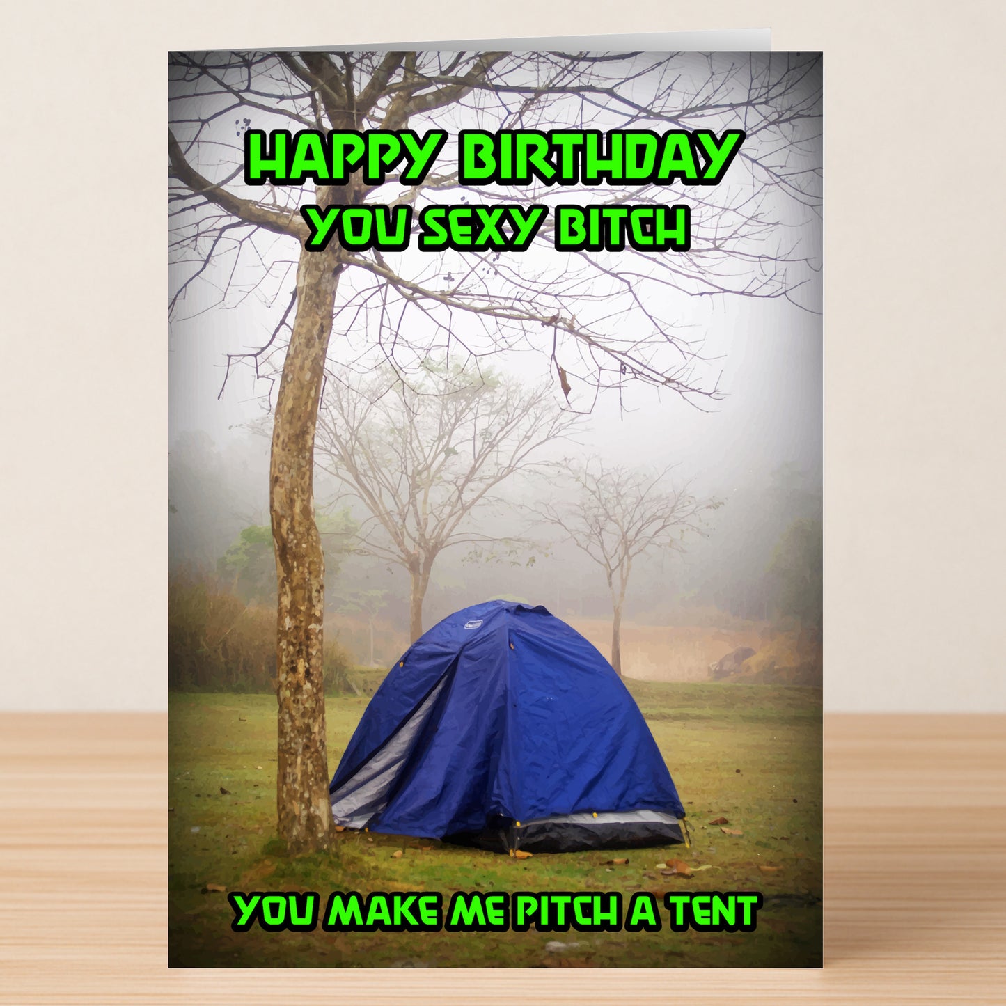 The Pitch A Tent – Rude Birthday Card by Twisted Gifts features a blue tent under a tree in foggy outdoors, with bold green text: "Happy Birthday you sexy bitch. You make me pitch a tent." Perfect for anyone with a wicked sense of humor.