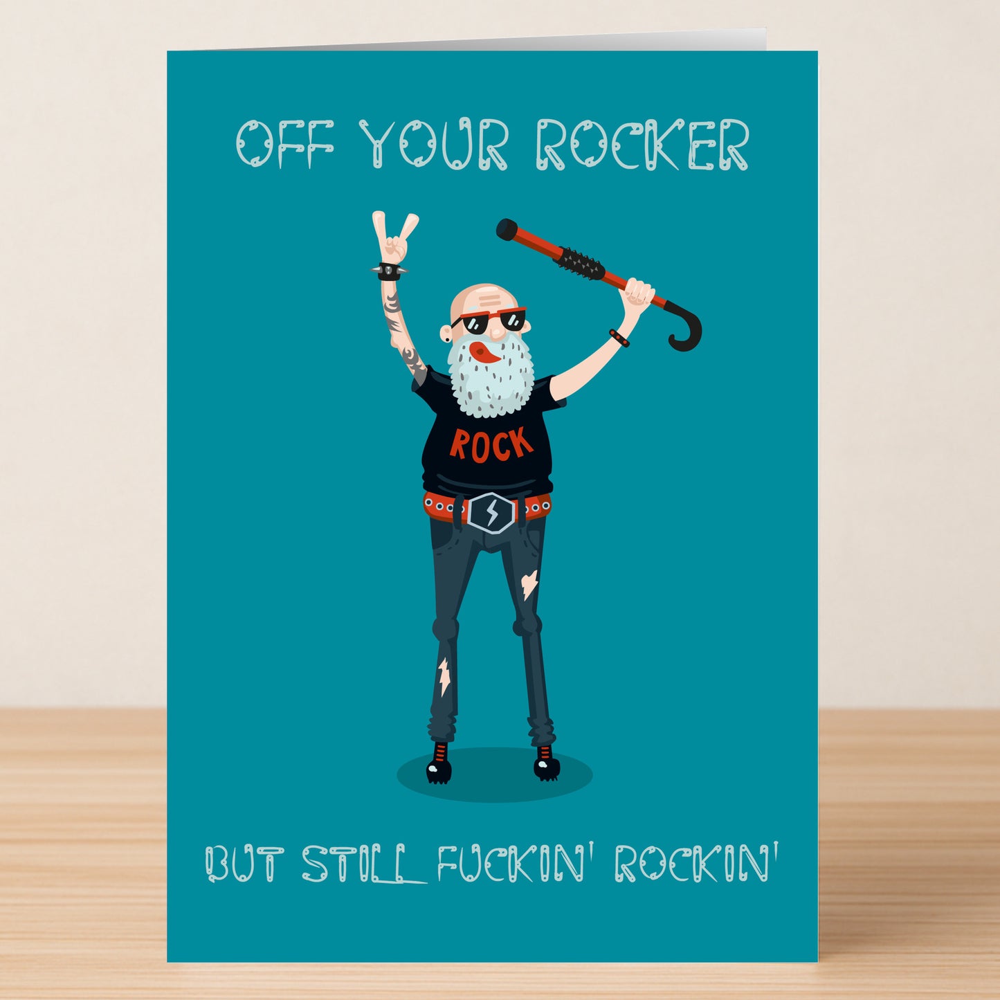 The Rocker – Funny Birthday Card by Twisted Gifts features an older man in rock attire with a cane, making a hand gesture and the text "OFF YOUR ROCKER BUT STILL FUCKIN' ROCKIN'" on teal—a hilarious choice for bold-humored birthdays.