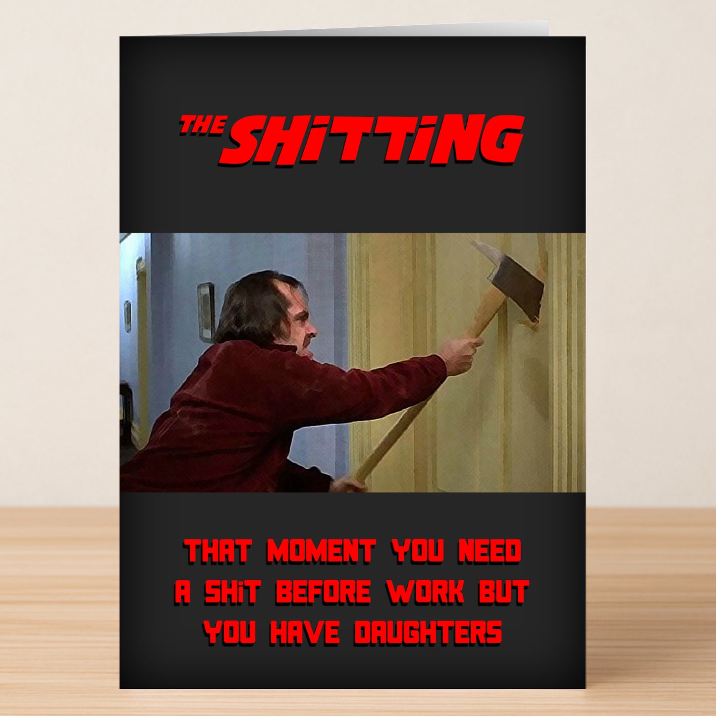 The Shitting – Funny Birthday Card by Twisted Gifts features a man with an axe breaking through a door, referencing "The Shining," with a joke about needing the bathroom before work but having daughters.
