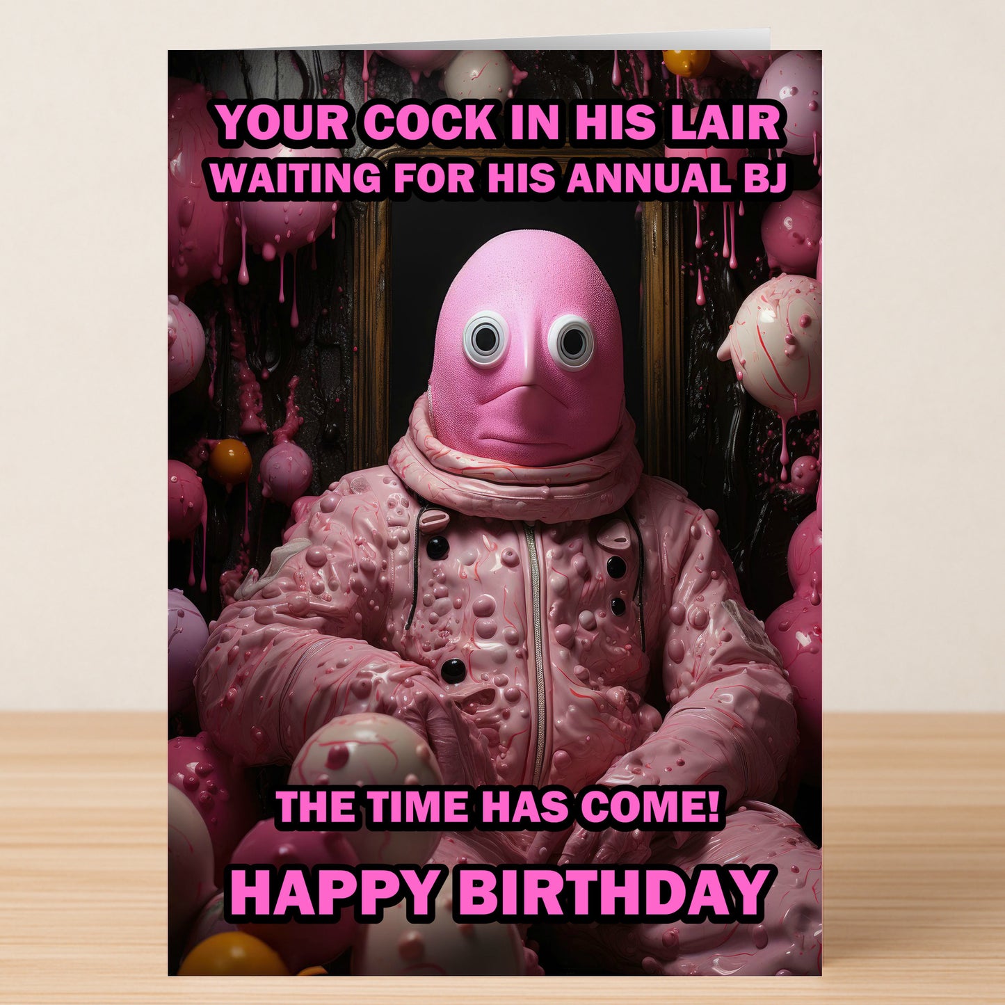 A person in a textured pink costume with large googly eyes sits in a surreal, pink setting as bold text from Twisted Gifts’ “Lair – Rude Birthday Card” delivers its hilarious message.