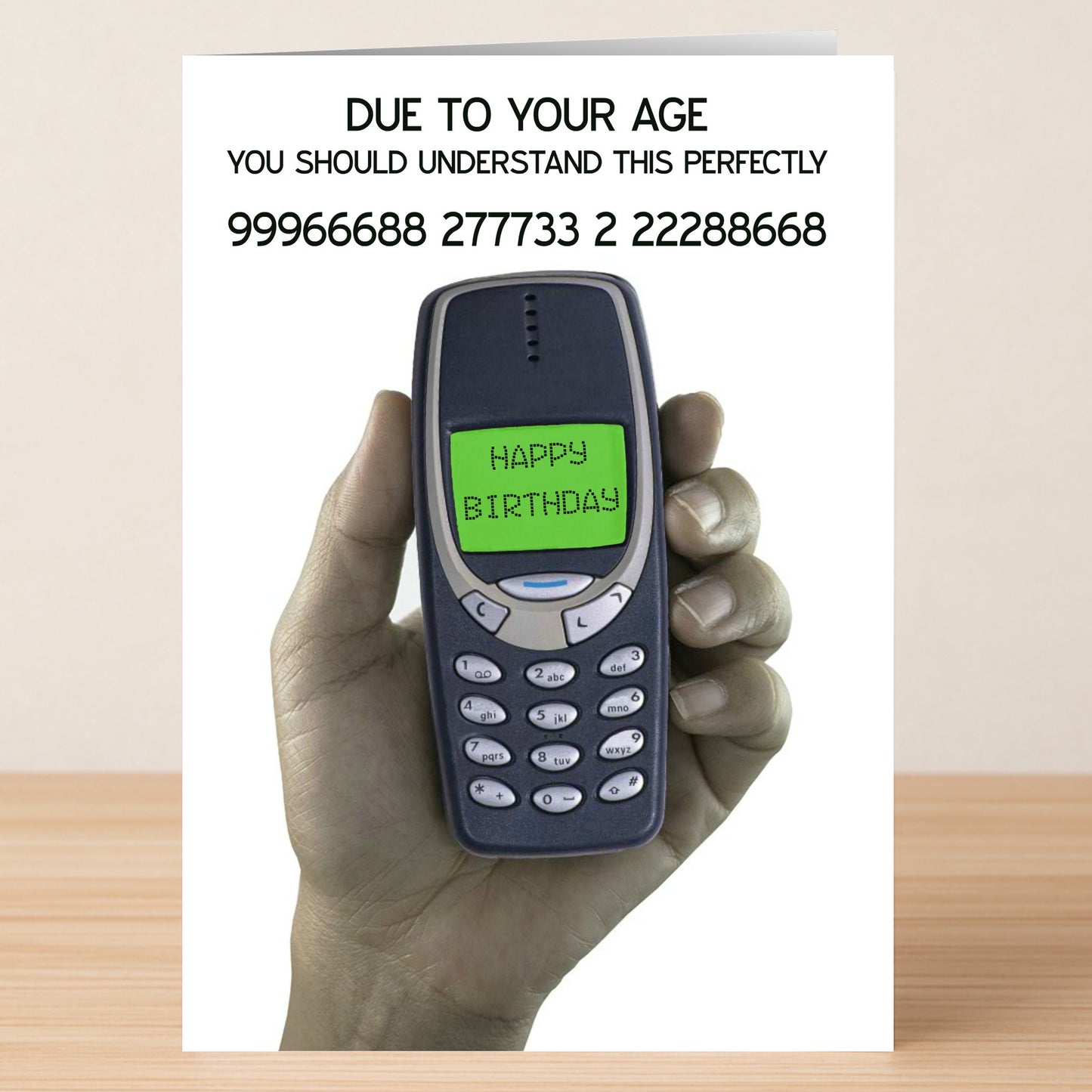 A hand holds a vintage Nokia with "HAPPY BIRTHDAY," captioned, "DUE TO YOUR AGE YOU SHOULD UNDERSTAND THIS PERFECTLY." Twisted Gifts’ Perfectly – Funny Birthday Card—sure to spark laughter and nostalgia!.