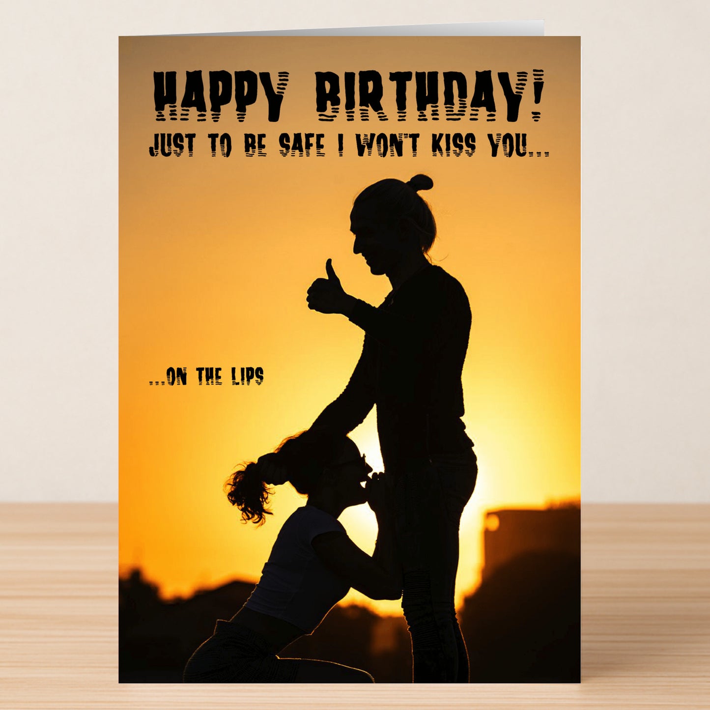 Twisted Gifts' "To Be Safe – Rude Birthday Card" features a sunset silhouette of one person kneeling to kiss another’s hand with the message: "Happy Birthday! Just to be safe I won't kiss you...on the lips." Perfect for a birthday laugh.