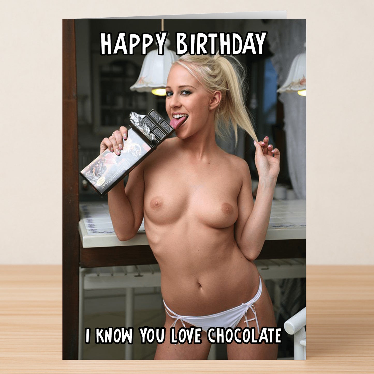 A saucy birthday card from Twisted Gifts. A topless woman is eating a bar of chocolate. The caption says "Happy Birthday", "I know you love chocolate"