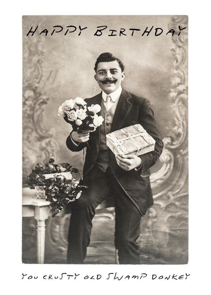 A funny Swamp Donkey Insulting Birthday Card featuring a man holding a bouquet of flowers by Twisted Gifts.