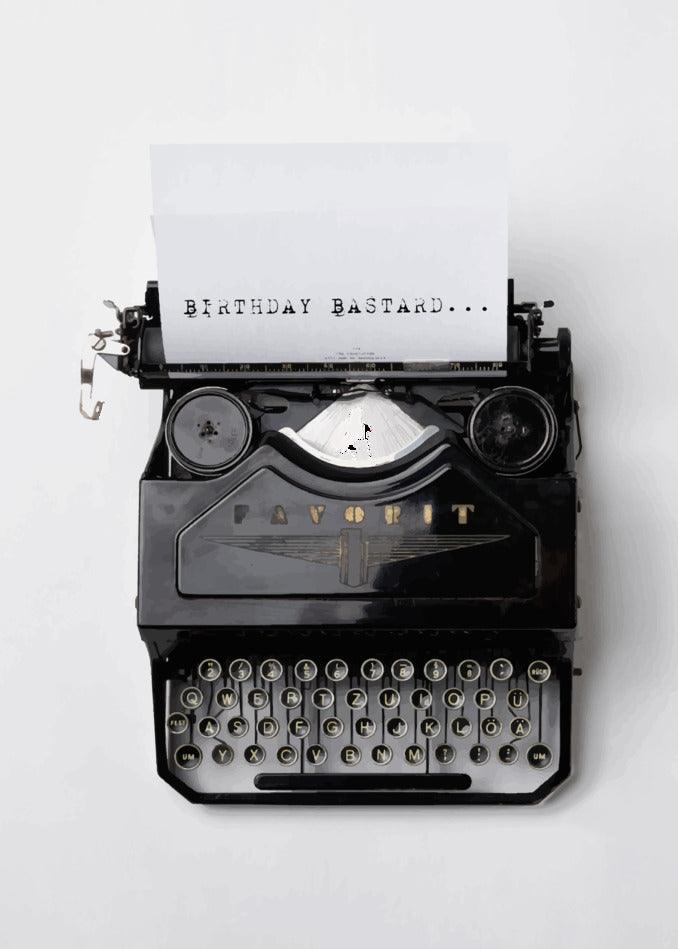 A humorous typewriter with a Bastard Insulting Birthday Card written on it, from Twisted Gifts.