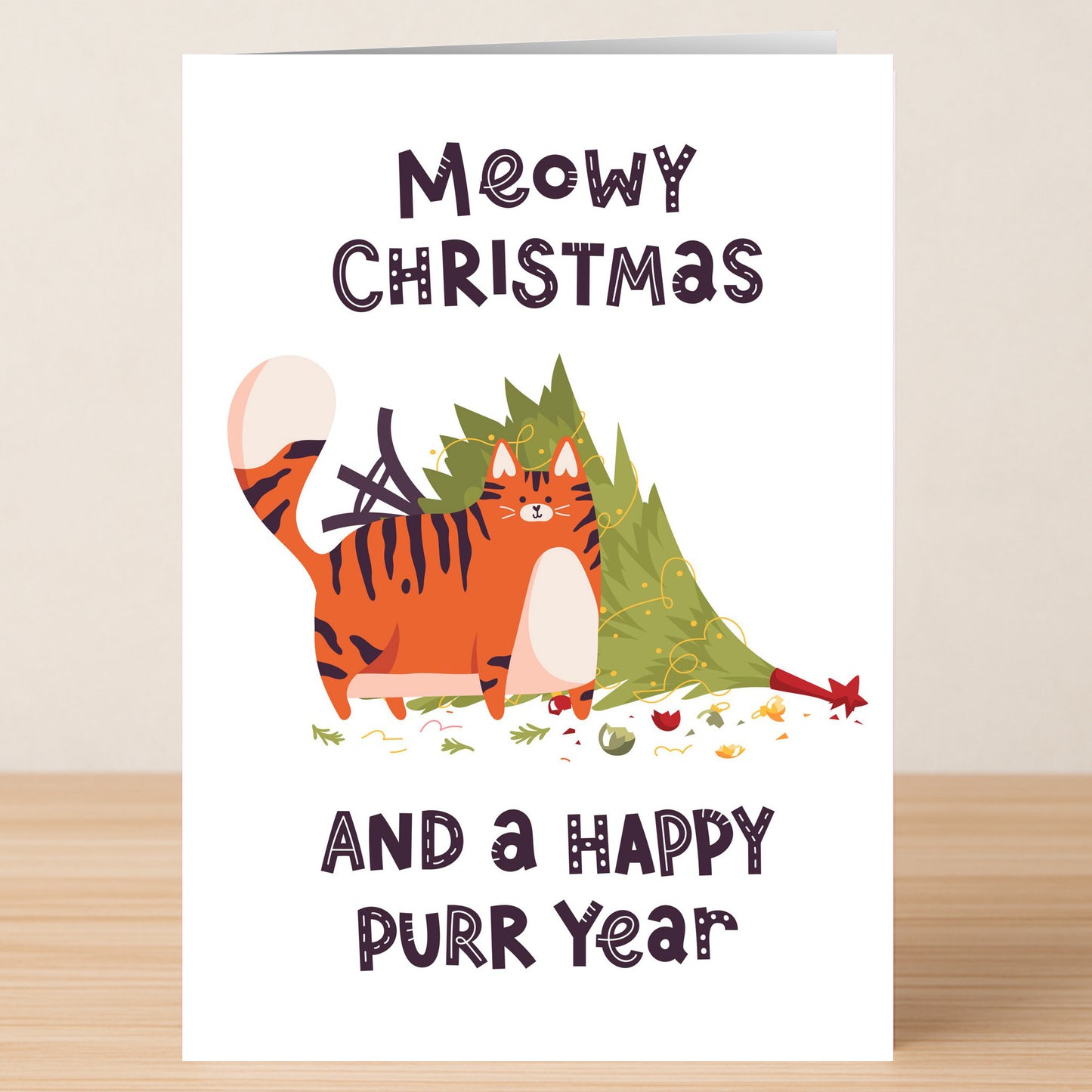 The Meow Christmas Card by Twisted Gifts features "Meowy Christmas and a Happy Purr Year" with a playful cat toppling a tree—an ideal addition to any cat lover's card collection!.