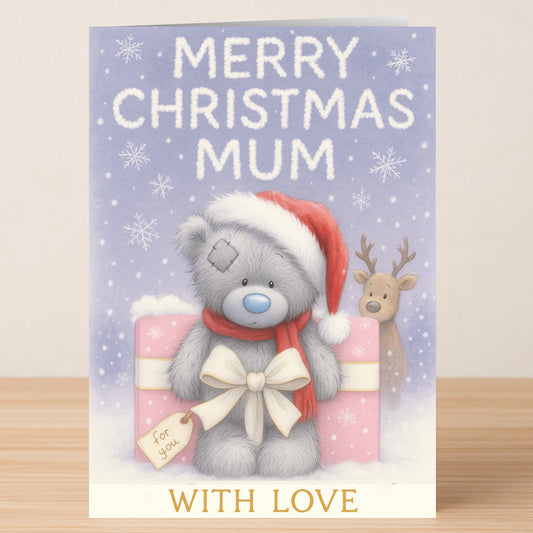 The Mum Bear Christmas Card by Twisted Gifts features a gray teddy in a Santa hat with a gift, a reindeer in the background, and the texts "MERRY CHRISTMAS MUM" and "WITH LOVE"—the perfect holiday card for your mum.