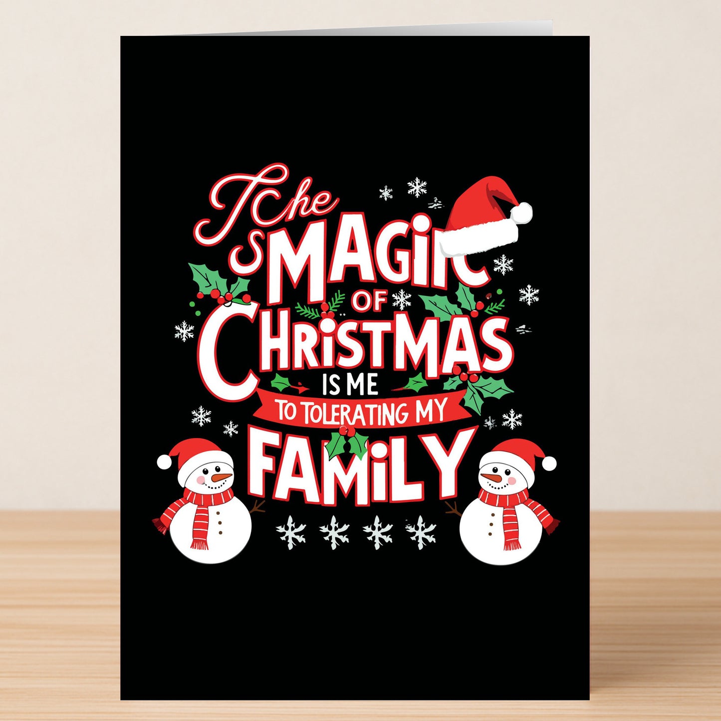 The Twisted Gifts Family Christmas Card features the text "The magic of Christmas is me tolerating my family" in festive colors with snowflakes, holly, two snowmen, and a Santa hat—a cheeky holiday card for fun-loving families.