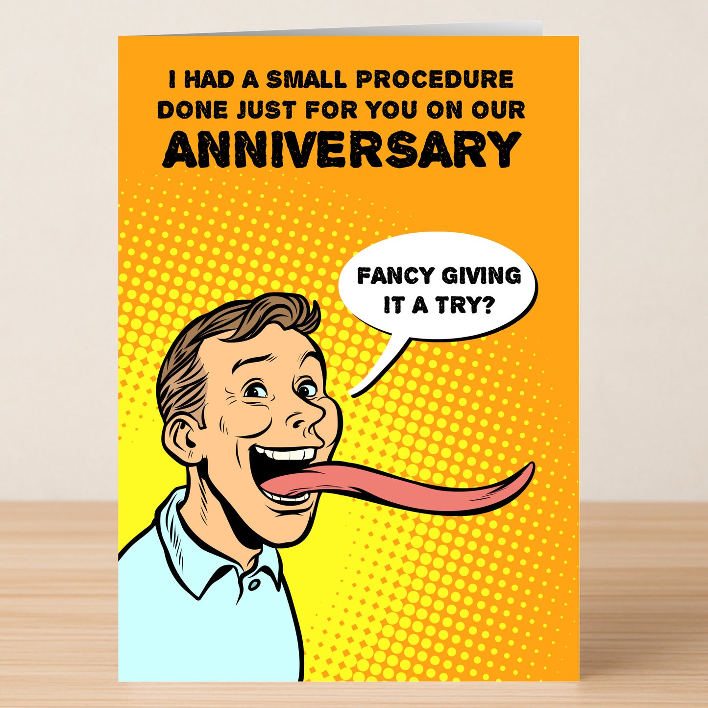 The Procedure Funny Anniversary Card by Twisted Gifts features a pop art man with a long tongue and the phrase "Fancy giving it a try?" on an orange background—ideal for anyone who enjoys witty wordplay and humor!.