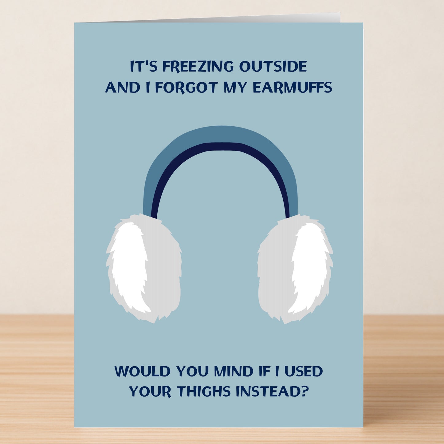 The Earmuffs Rude Greeting Card by Twisted Gifts features white earmuffs and the cheeky message, "It's freezing outside and I forgot my earmuffs. Would you mind if I used your thighs instead?"—perfect for a laugh.