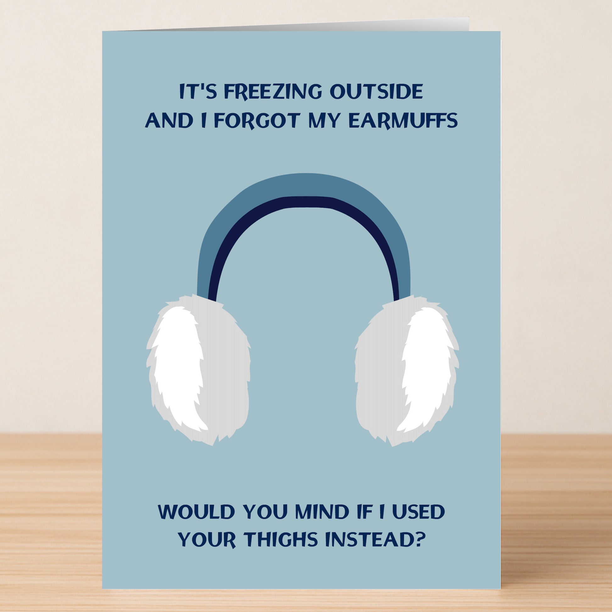 The Earmuffs Rude Greeting Card by Twisted Gifts features white earmuffs and the cheeky message, "It's freezing outside and I forgot my earmuffs. Would you mind if I used your thighs instead?"—perfect for a laugh.