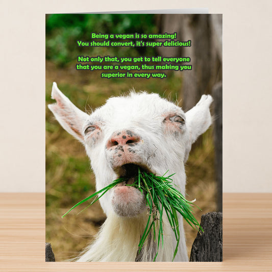 The Superior Funny Greeting Card by Twisted Gifts features a white goat chewing green grass with a witty vegan message in green text above—perfect for sharing laughs and brightening someone’s day.