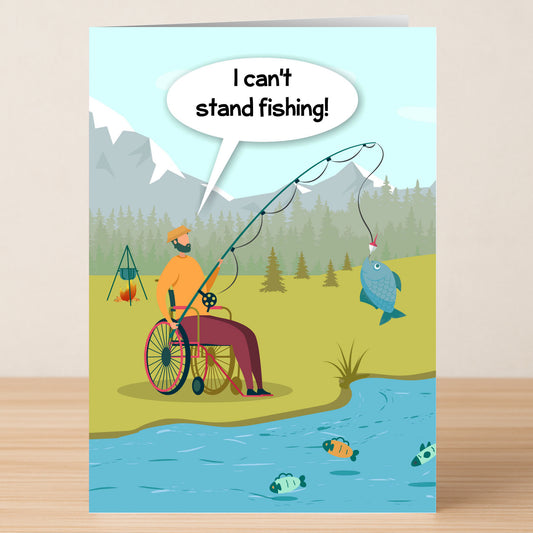 A fishing enthusiast in a wheelchair reels in a catch by the river, joking, "I can't stand fishing!"—the perfect witty message featured on Twisted Gifts' Can't Stand Fishing Funny Greeting Card.