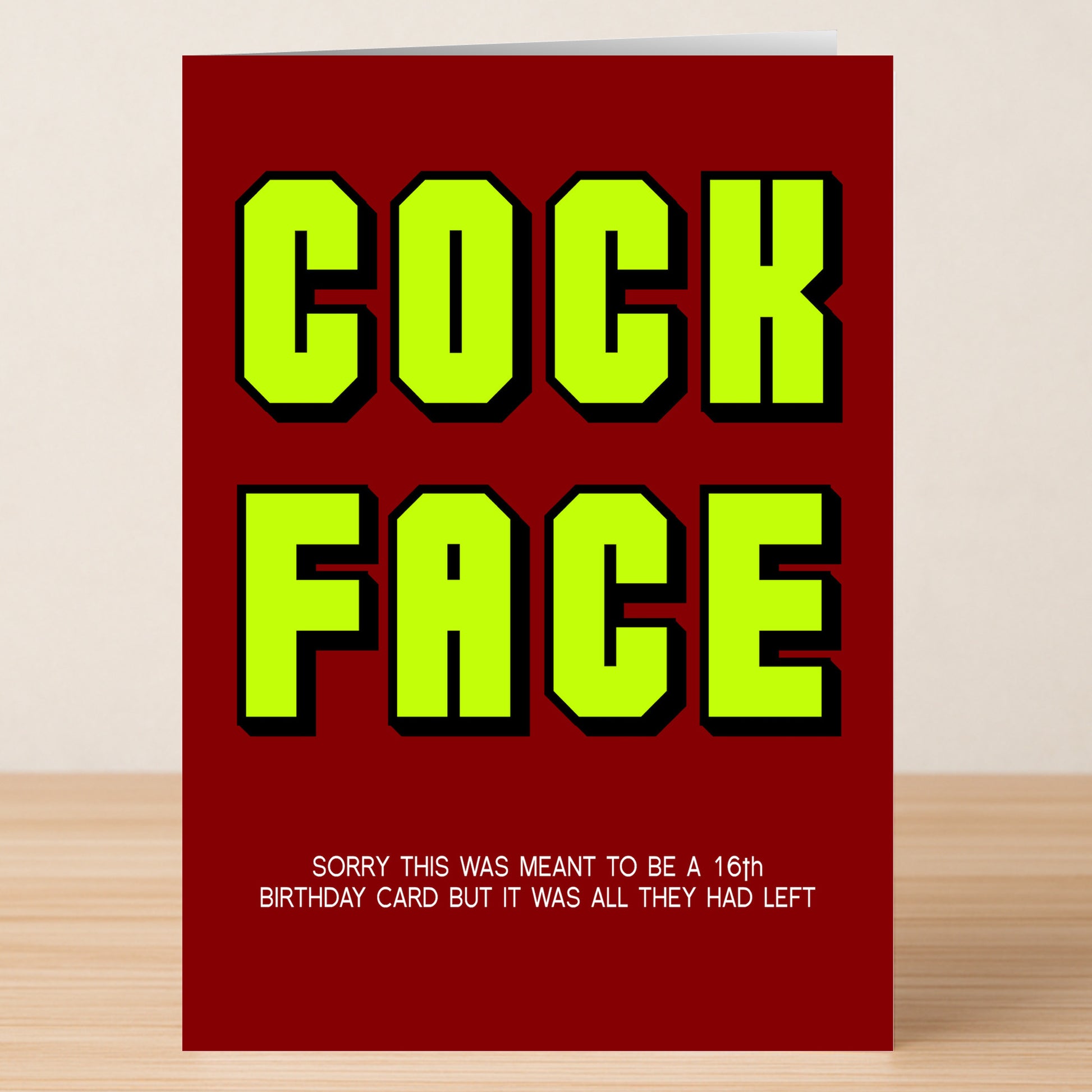 The "16 - Cock Face 16 Insulting Birthday Card" by Twisted Gifts features bold yellow-green text "COCK FACE" on a red background, plus a witty caption: "Sorry this was meant to be a 16 today birthday card but it was all they had left.