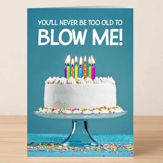 The Blow Me Rude Birthday Card by Twisted Gifts features a cake with lit candles on a glass stand and the cheeky text "You'll never be too old to BLOW ME!"—a funny way to wish someone a happy birthday!.