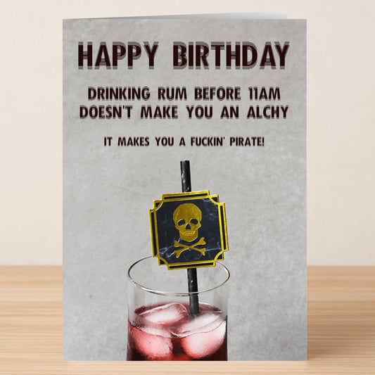 The Pirate Funny Birthday Card by Twisted Gifts features a drink with a skull and crossbones stirrer and reads: "Happy Birthday. Drinking rum before 11am doesn't make you an alchy, it makes you a fuckin' pirate!.