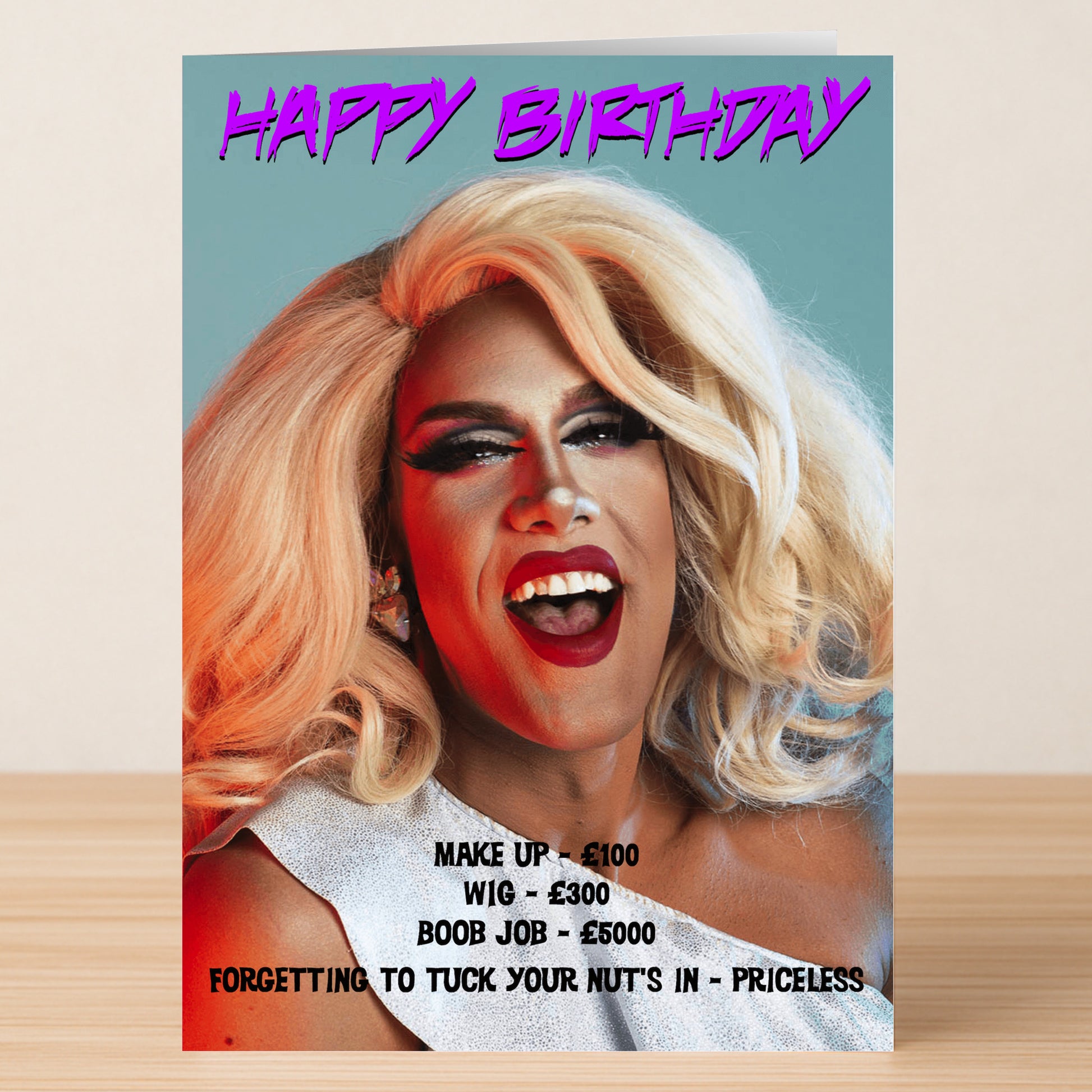 The Priceless Funny Birthday Card by Twisted Gifts features a drag queen with dramatic makeup and blonde wig, laughing alongside witty text about drag costs and a playful birthday greeting.