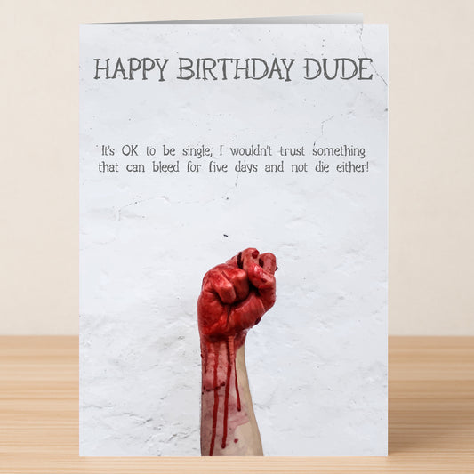 The "It's Ok Insulting Birthday Card" by Twisted Gifts features "HAPPY BIRTHDAY DUDE" over a single-life joke and a raised, blood-covered fist illustration.