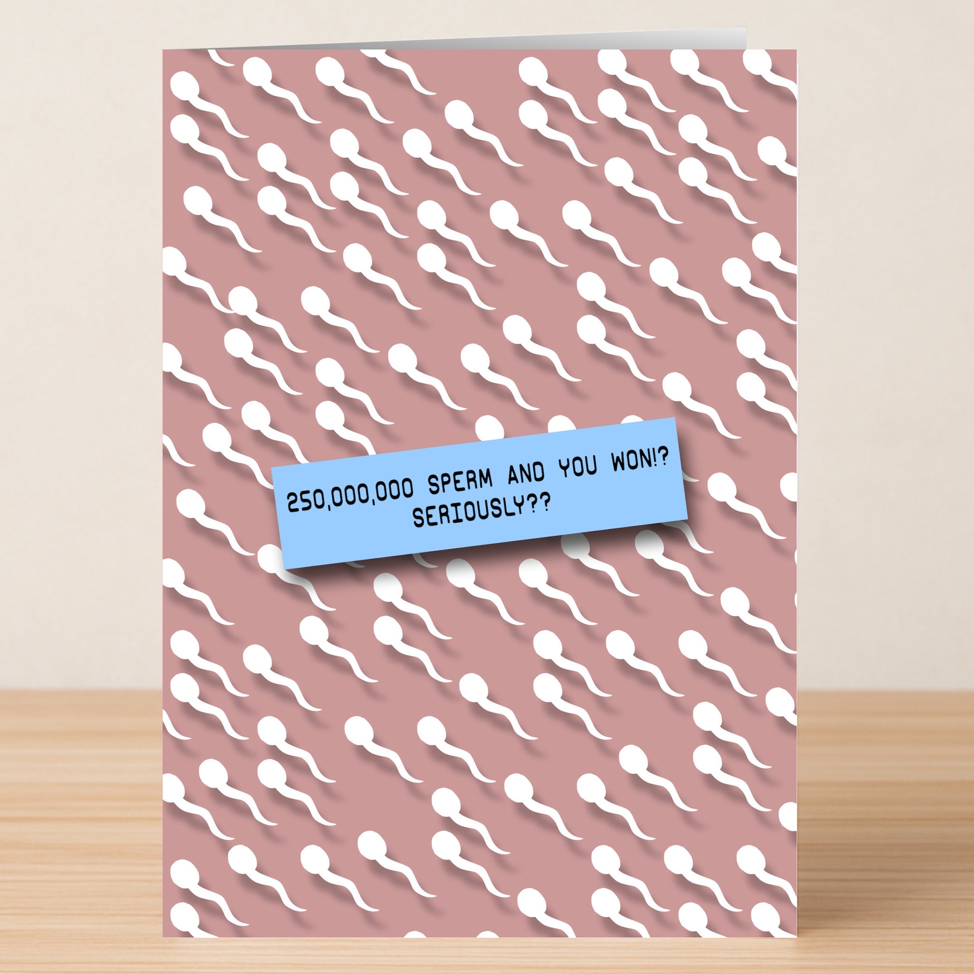 The Sperm, Seriously? Rude Birthday Card by Twisted Gifts features white sperm illustrations on a pink background and the funny message: “250,000,000 sperm and you won!? Seriously??”.
