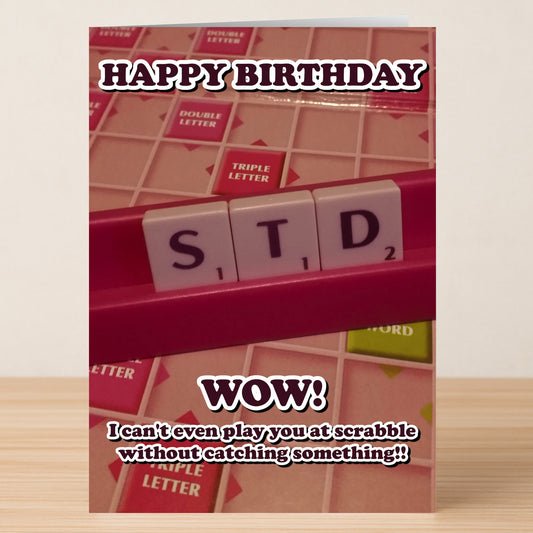 The Scrabble Rude Birthday Card by Twisted Gifts features letter tiles spelling "STD" and the message, "Happy Birthday. Wow! I can't even play you at Scrabble without catching something!"—a colorful, humorous choice.