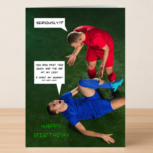 Two soccer players on grass—one in red stands, gesturing, one in blue lies holding his leg. Comic speech bubbles and "Happy Birthday" add humor to this Twisted Gifts "More Money Insulting Birthday Card," a funny birthday card design.