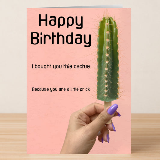 A hand with purple nails holds Twisted Gifts' Little Prick Insulting Birthday Card, featuring a cactus and the message "Happy Birthday. I bought you this cactus because you are a little prick." Ideal for friends who love playful banter.