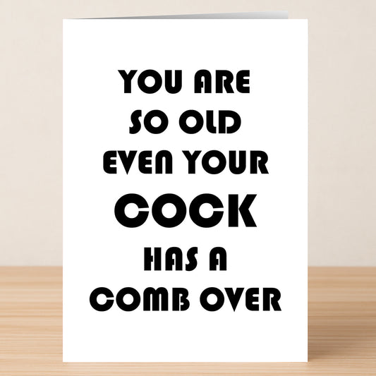 The Comb Over Rude Birthday Card by Twisted Gifts features a witty design on a wooden surface, with the bold message: "You are so old even your cock has a comb over.