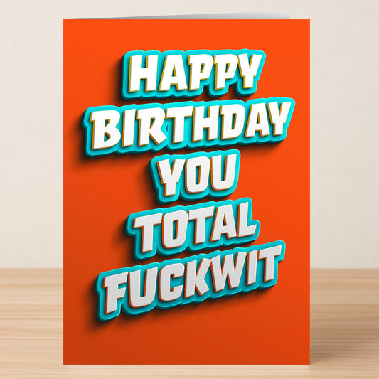 The Total Fuckwit Insulting Birthday Card by Twisted Gifts features bold white and blue text on orange, reading "HAPPY BIRTHDAY YOU TOTAL FUCKWIT." A unique, cheeky birthday card for those who love a laugh.