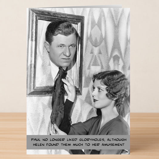 A woman playfully fixes a man's tie as his head pops through a picture frame—Amusement, Rude Birthday Card by Twisted Gifts is perfect for birthdays with a cheeky caption at the bottom.