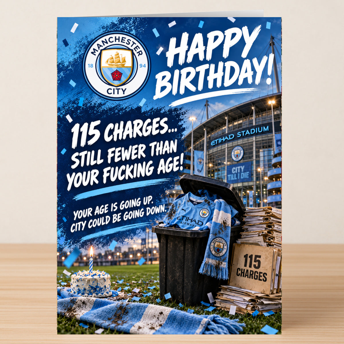 A Man City – Funny Birthday Card showing the Manchester City crest above a cake on a pitch, with a trash can containing a team jersey and files labeled “115 CHARGES.”