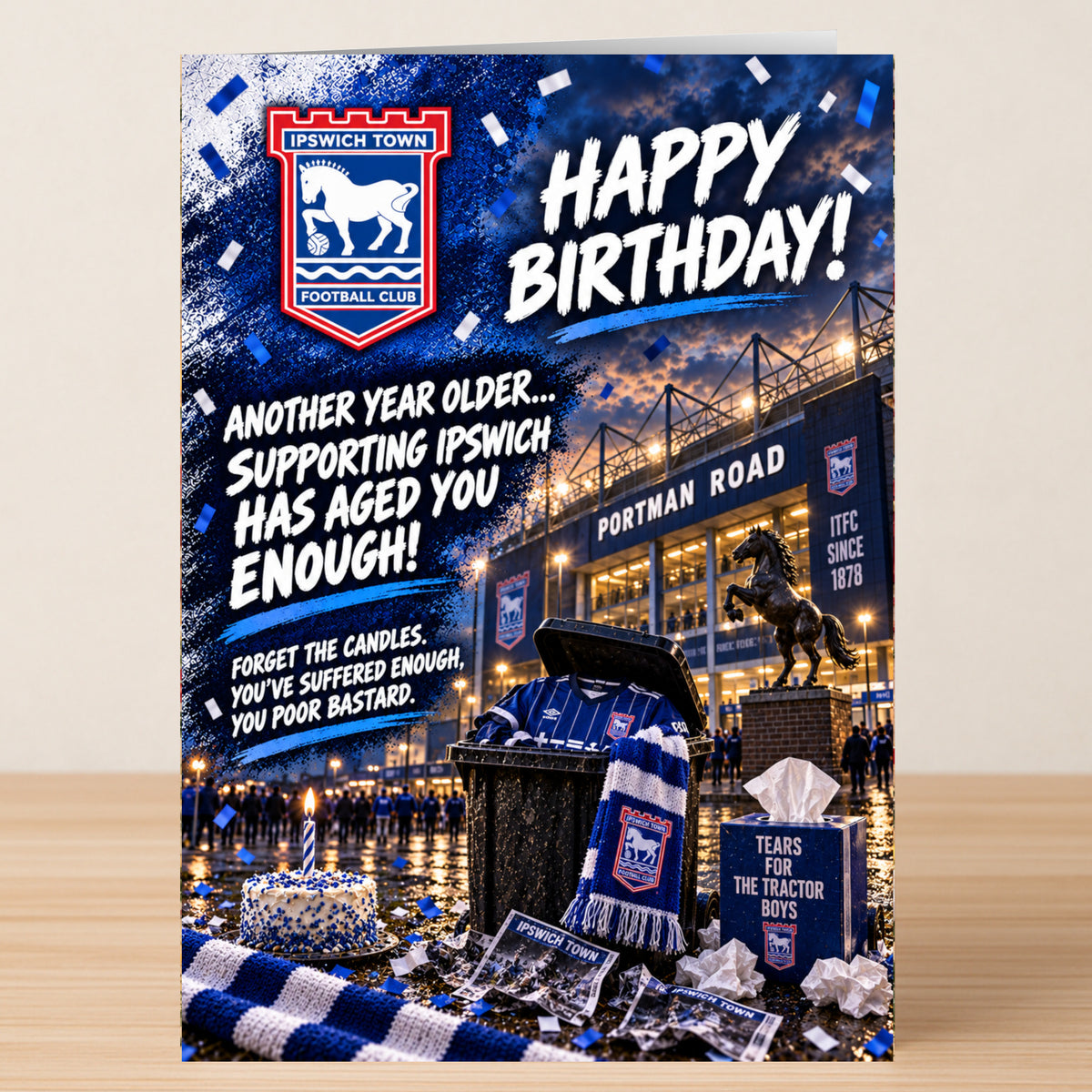 The Ipswich Town – Funny Birthday Card features a stadium background, a trash can with a jersey and scarf, a box of tissues labeled “Tears for the Tractor Boys,” and a birthday cake.