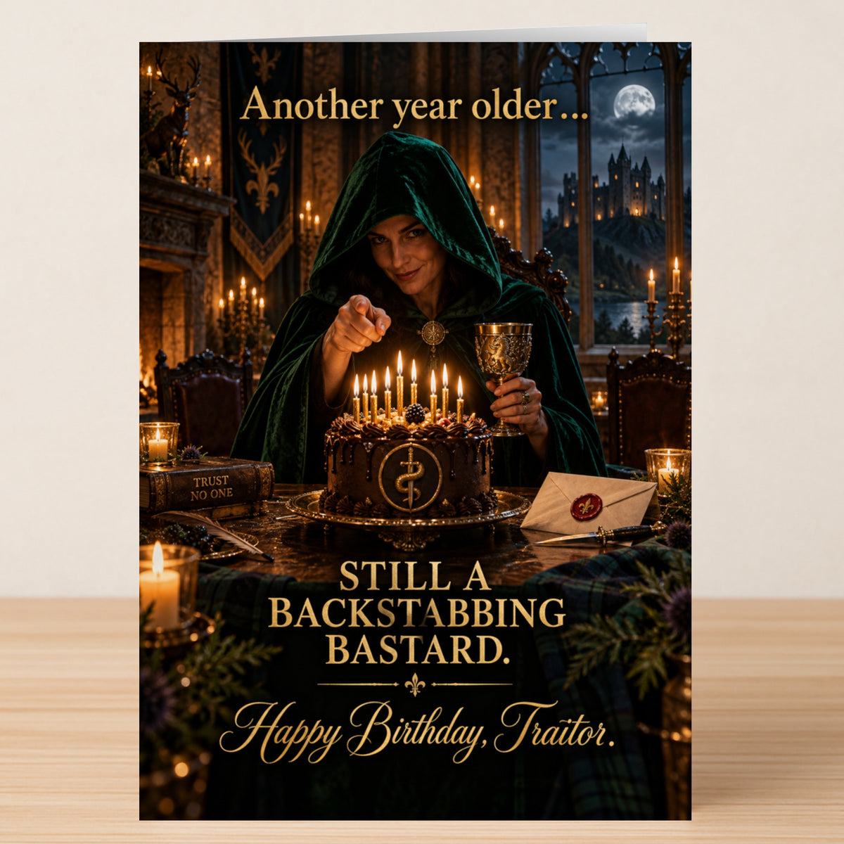 Traitor – Funny Birthday Card showing a person in a green hooded cloak pointing at a birthday cake with candles, inscribed: “Another year older... STILL A BACKSTABBING BASTARD. Happy Birthday, Traitor.”