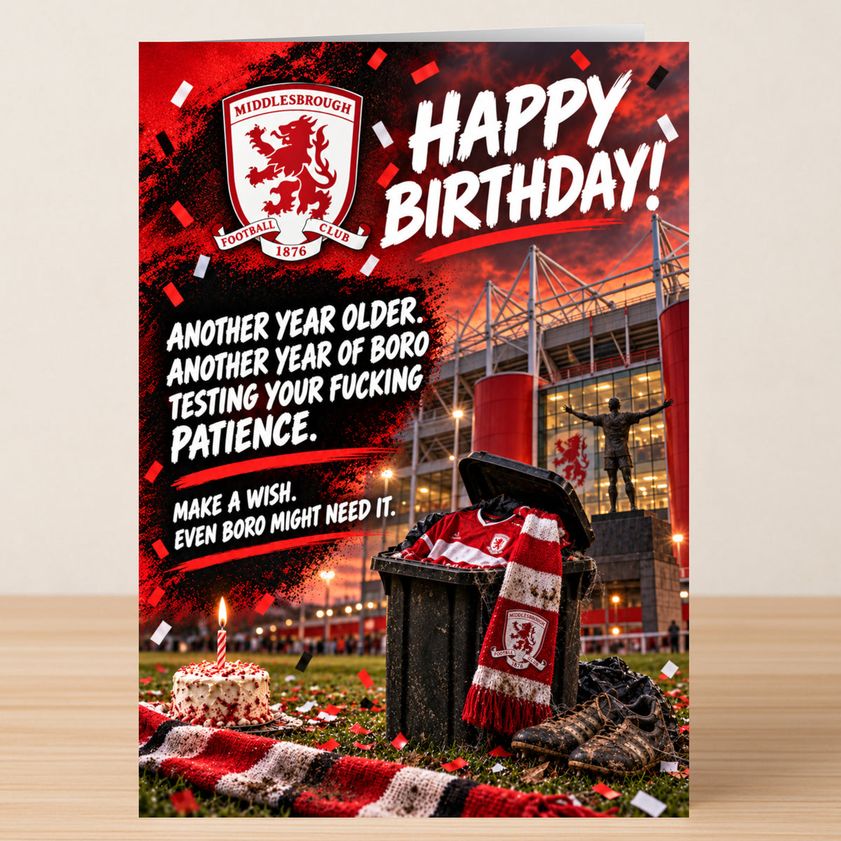 A Middlesbrough – Funny Birthday Card by Twisted Gifts featuring the Middlesbrough FC logo, a stadium backdrop, a bin with team gear, a cake, and text reading “Another year older. Another year of Boro testing your patience. Make a wish.”