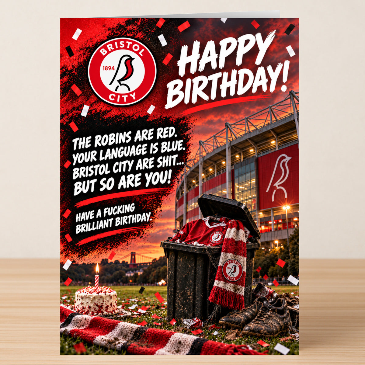 A Bristol City – Funny Birthday Card showing a soccer stadium, a trash can filled with team apparel, and a cake, with text reading: “The Robins are red. Your language is blue. Bristol City are shit... but so are you!”.