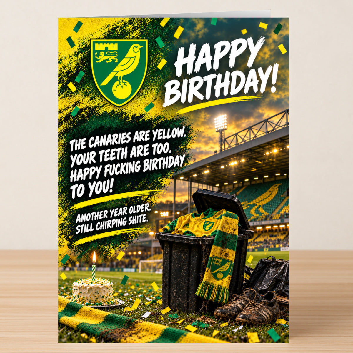 Norwich City – Funny Birthday Card featuring a soccer stadium, a birthday cake, and a trash bin filled with a jersey and scarf, reading: “Happy Birthday! The canaries are yellow. Your teeth are too.”