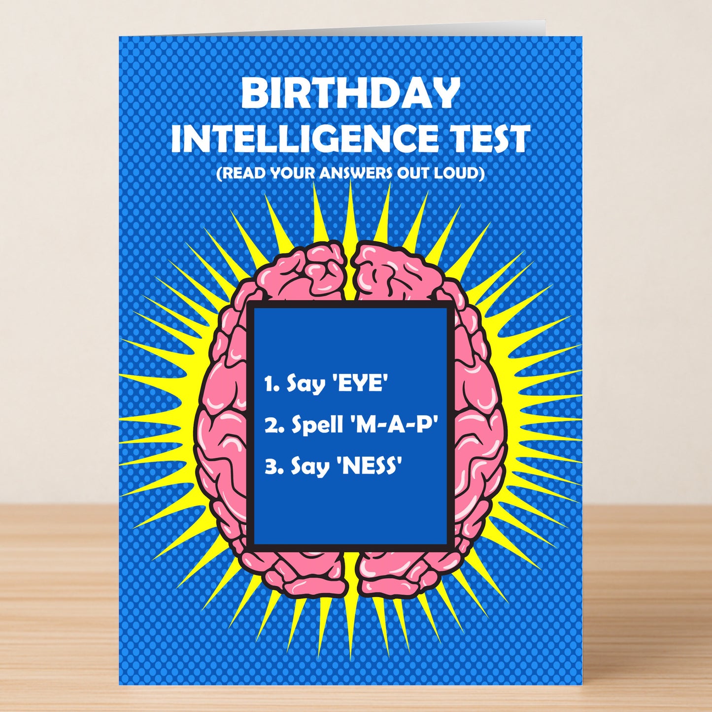 Give a clever birthday surprise with Twisted Gifts’ Intelligence Insulting Birthday Card—featuring a cartoon brain on blue and the “Birthday Intelligence Test” challenge: "1. Say 'EYE,' 2. Spell 'M-A-P,' 3. Say 'NESS.'.