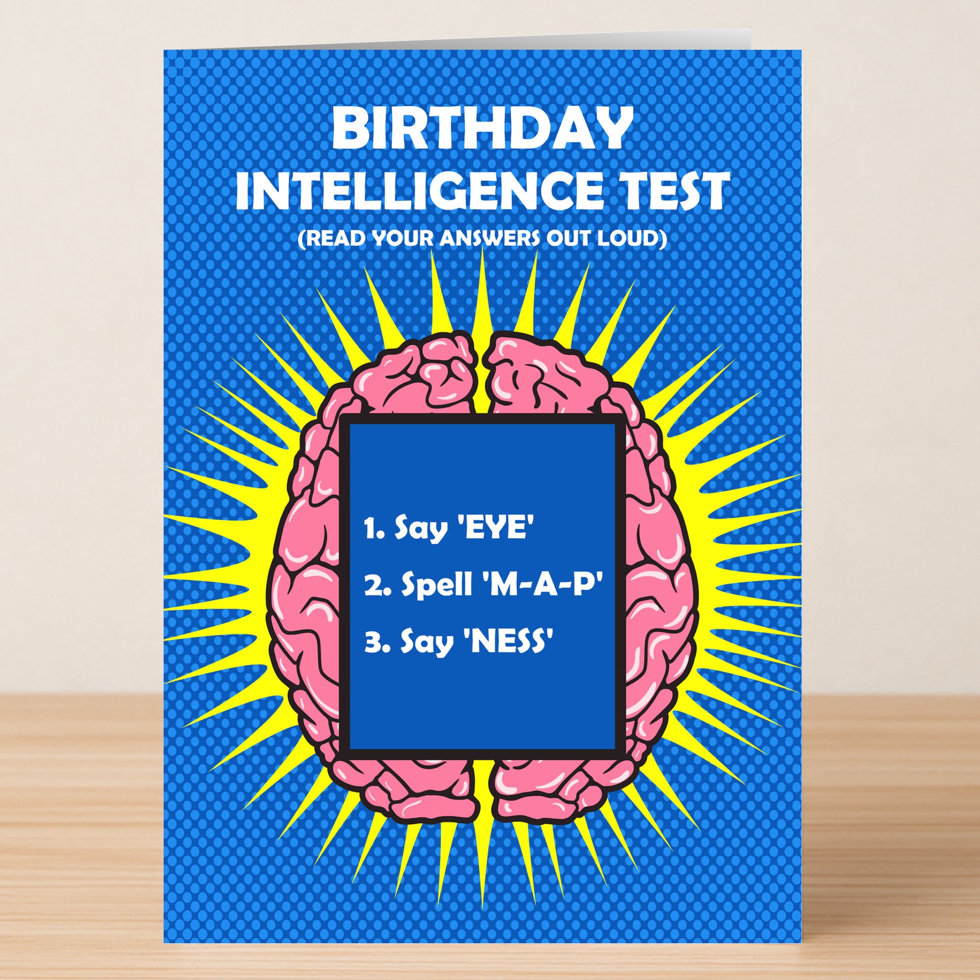 Give a clever birthday surprise with Twisted Gifts’ Intelligence Insulting Birthday Card—featuring a cartoon brain on blue and the “Birthday Intelligence Test” challenge: "1. Say 'EYE,' 2. Spell 'M-A-P,' 3. Say 'NESS.'.