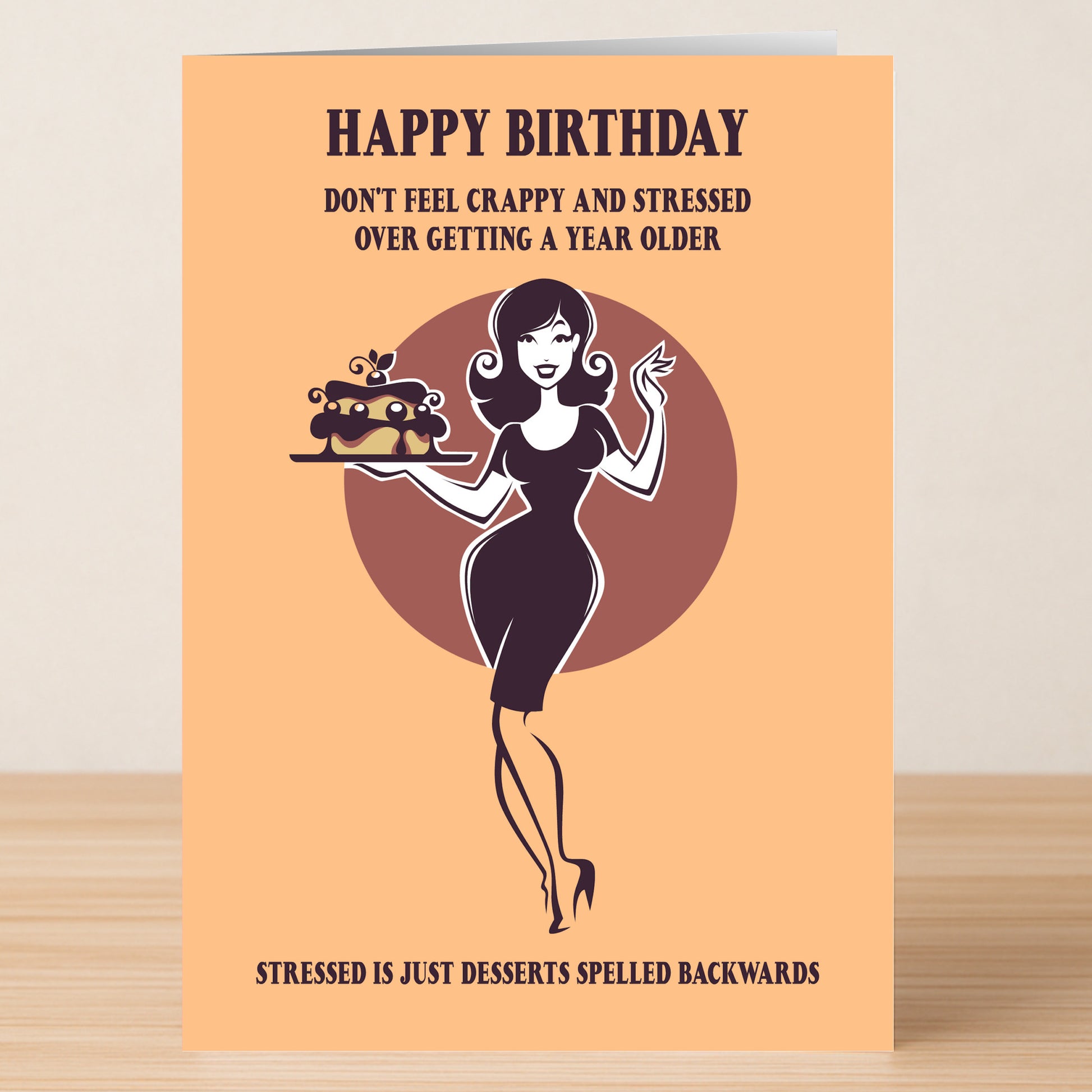 The Stressed Funny Birthday Card from Twisted Gifts features a woman with a cake and witty text about birthdays, cleverly playing on “stressed” spelled backward as “desserts.”.