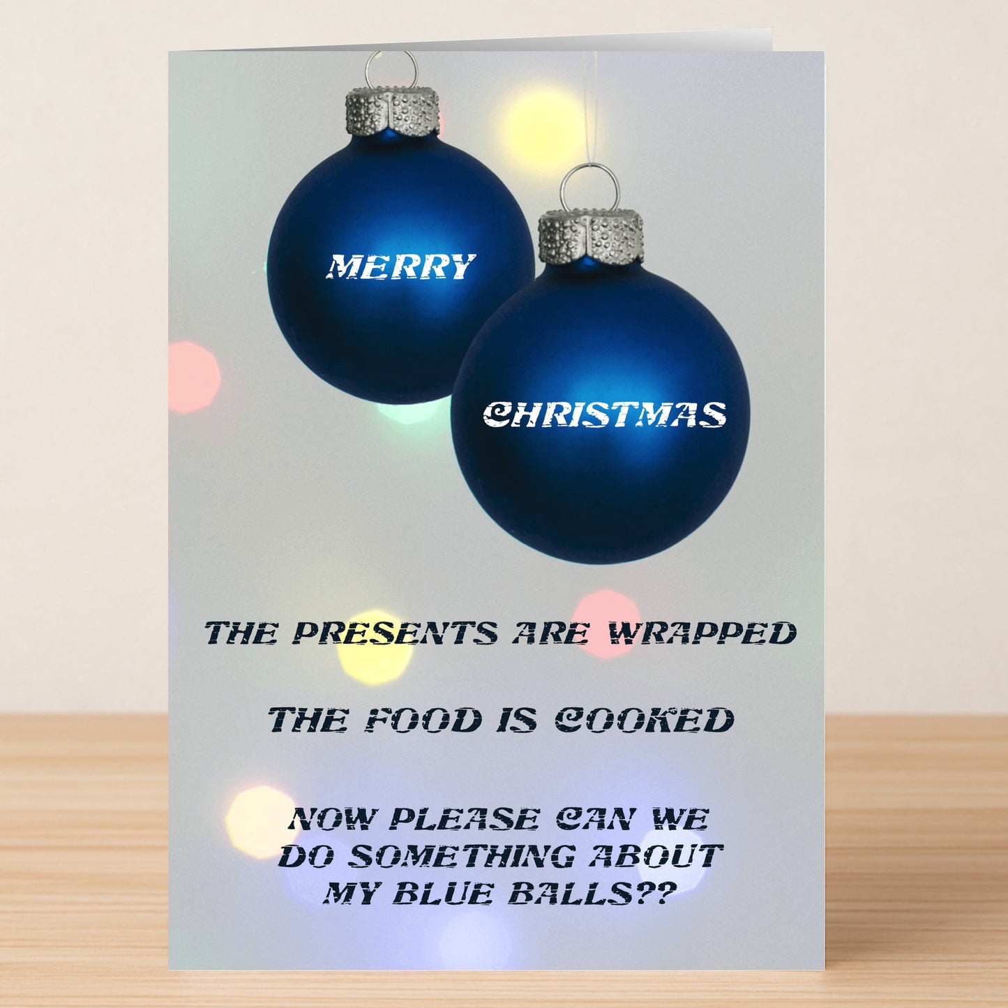 The Presents Funny Christmas Card by Twisted Gifts features two blue ornaments labeled "Merry" and "Christmas" with a witty message about gifts, food, and "blue balls"—a festive way to add laughter to the holidays.