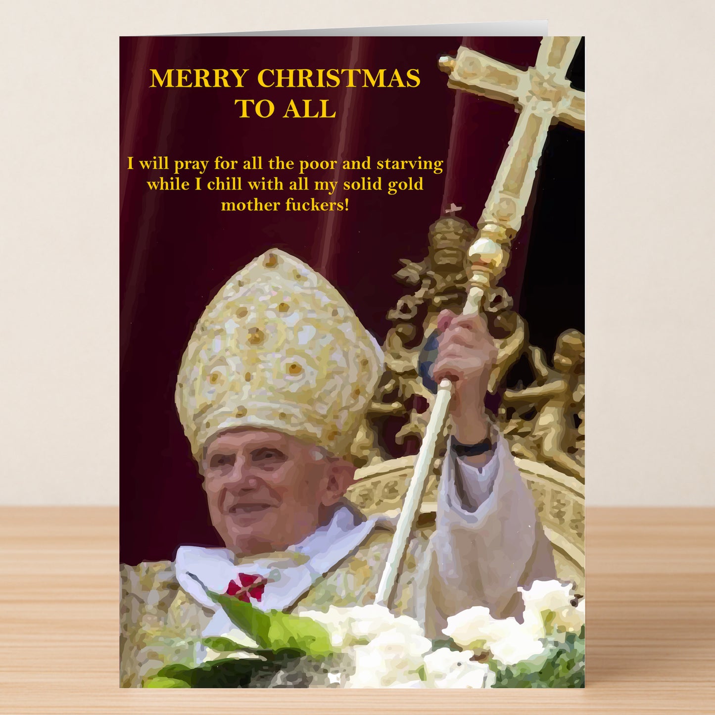 A Solid Gold Rude Christmas Card by Twisted Gifts shows a religious leader in gold vestments holding a staff, raising his hand with a bold yellow satirical holiday message above and beside him.