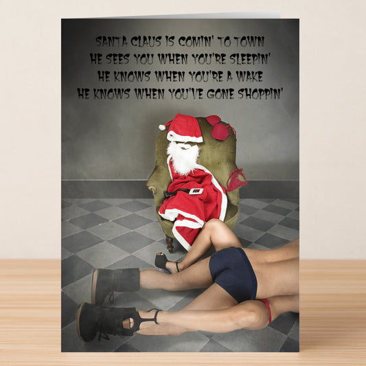 A Twisted Gifts Gone Shopping Rude Christmas Card features Santa seated on a chair and another figure in underwear and heels on the floor, with bold song lyrics on the wall for a humorous holiday design.