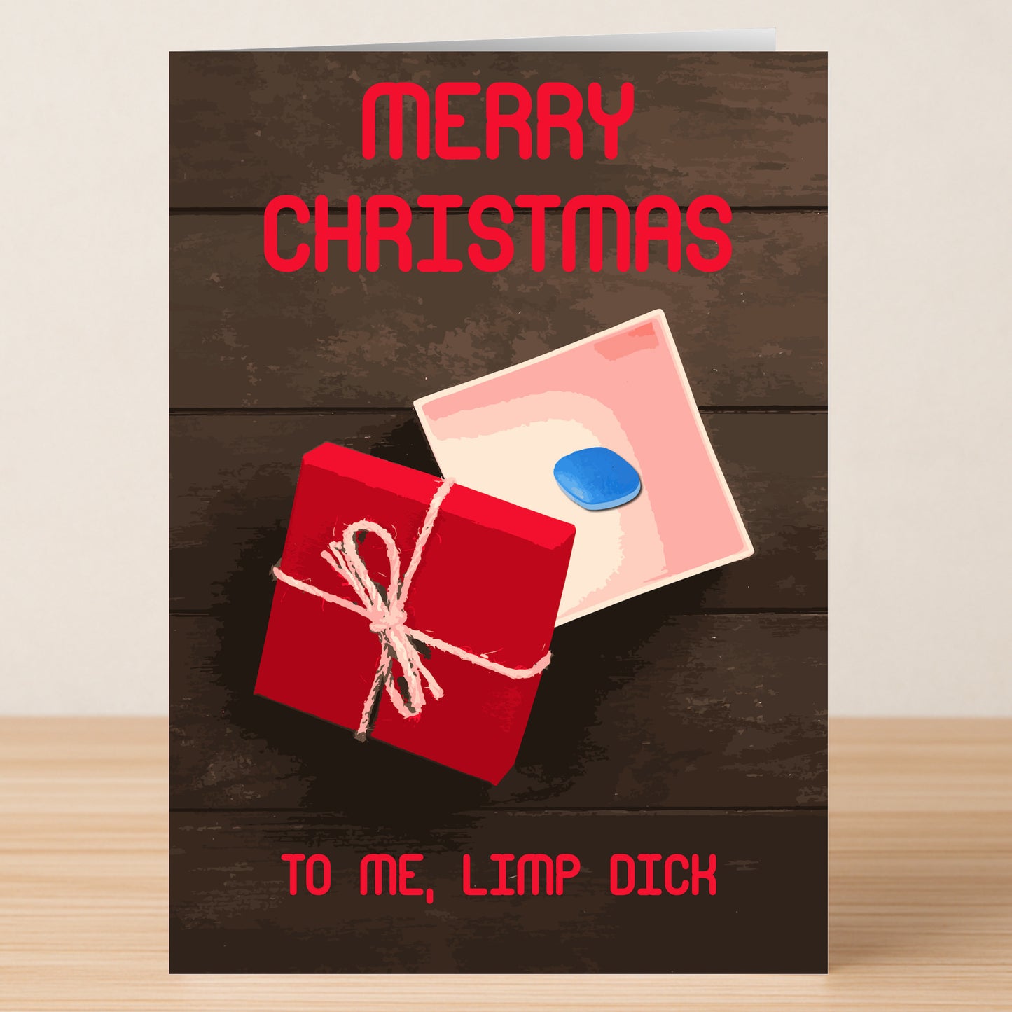 Send cheeky holiday wishes with the Limp Dick Rude Christmas Card by Twisted Gifts—featuring "Merry Christmas," a red gift box with a rope bow, and bold "To me, limp dick" text for those who enjoy cards with attitude.