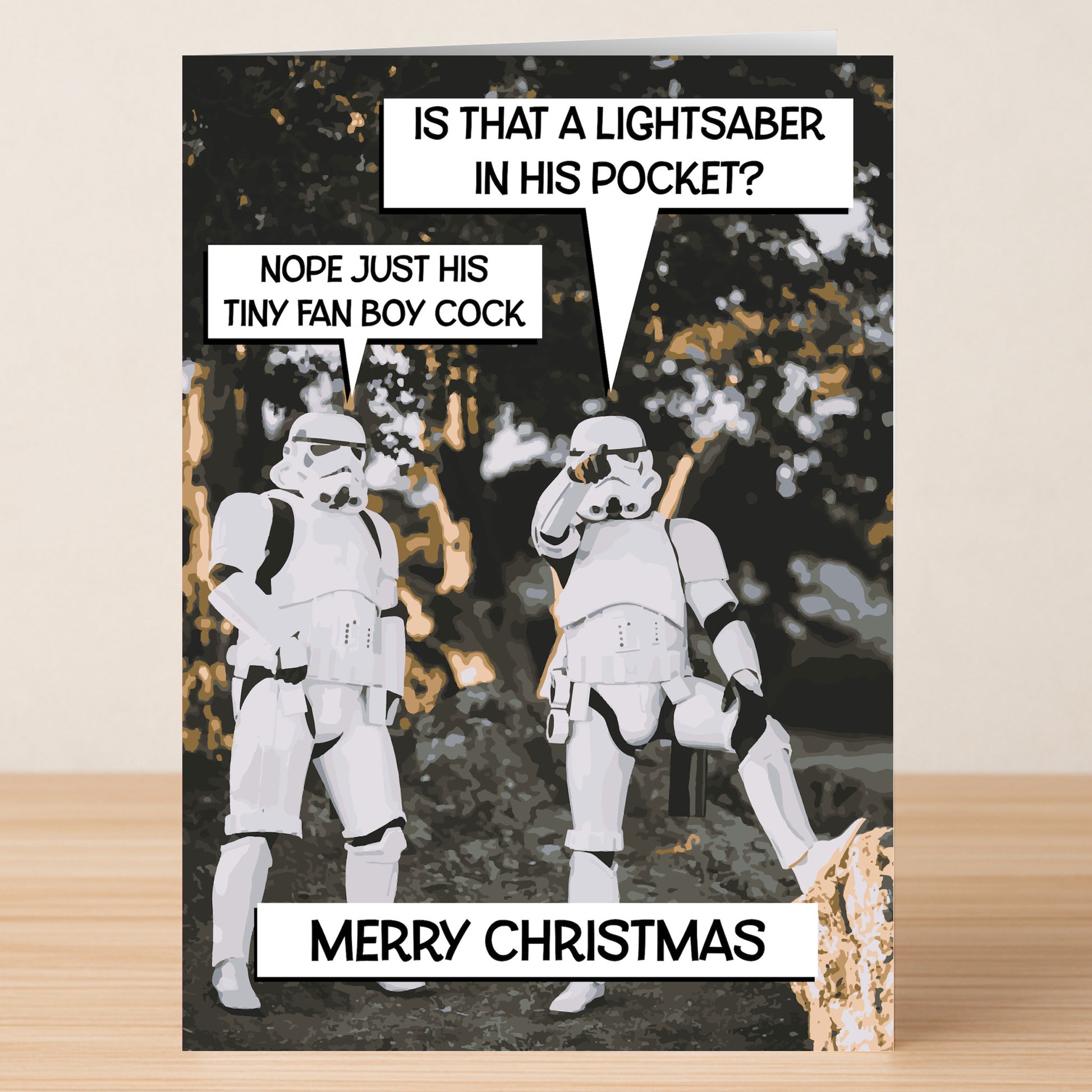 Two Stormtroopers stand outdoors; one points as comic-style speech bubbles with lightsaber-themed holiday jokes float above. “Merry Christmas” finishes this Lightsaber Rude Christmas Card by Twisted Gifts at the bottom.