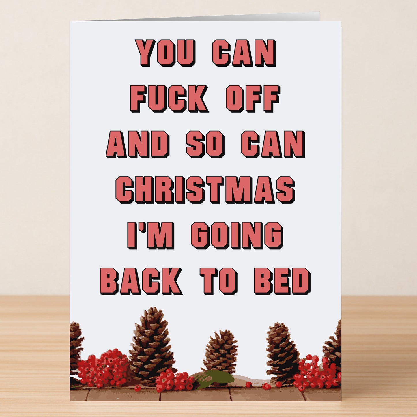 The Back To Bed Rude Christmas Card by Twisted Gifts features the message "You can fuck off and so can Christmas. I'm going back to bed," plus pinecones and red berries—a bold, hilarious alternative to classic holiday cards.