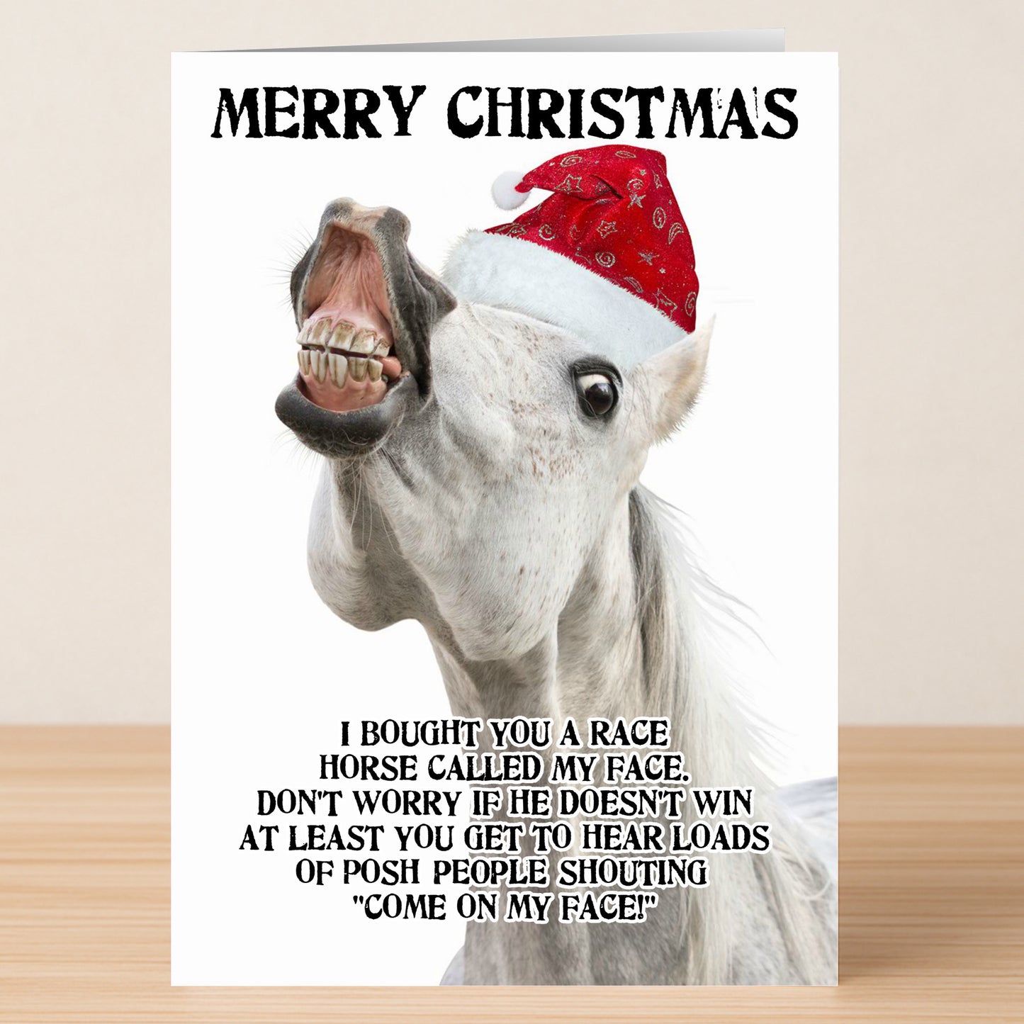 A white horse in a red Santa hat grins on the Twisted Gifts My Face Non-Rude Christmas Card, with "Merry Christmas" above and a funny message below—perfect for anyone who loves a festive laugh.